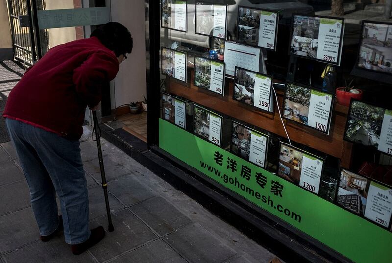 上海一家房地产中介公司的橱窗上展示着公寓广告牌。(路透社)