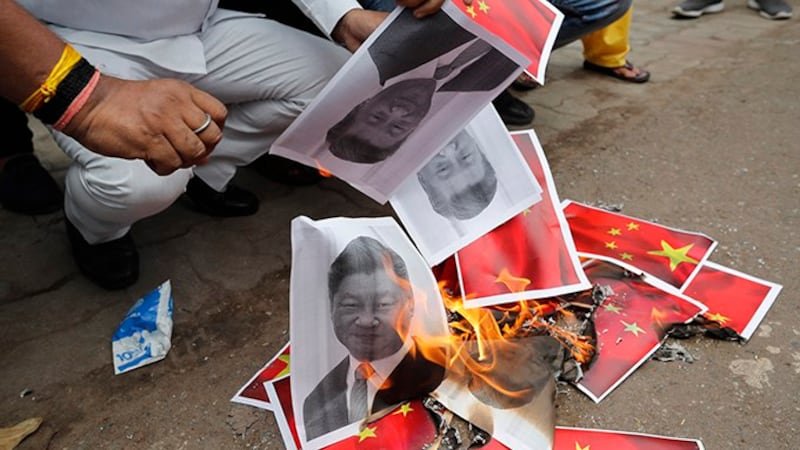 2020年6月17日,民众在印度一座城市的街头焚烧中国领导人习近平画像及中国国旗。(美联社)