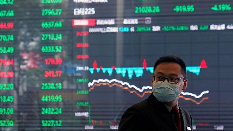 市场憧憬中国大陆推出更多刺激经济政策,上证综合指数周一升幅3.1%,深证成份指数升幅则有3.6%。两市成交额10293亿。图为,上海浦东金融区,一名戴着防护口罩的在男子证券交易所。(路透社)